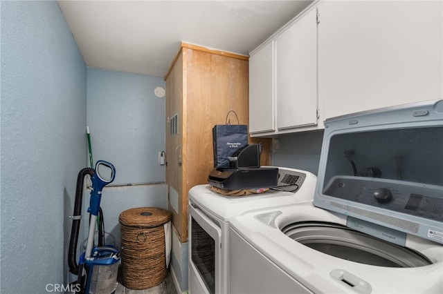 laundry area with cabinets and washing machine and clothes dryer