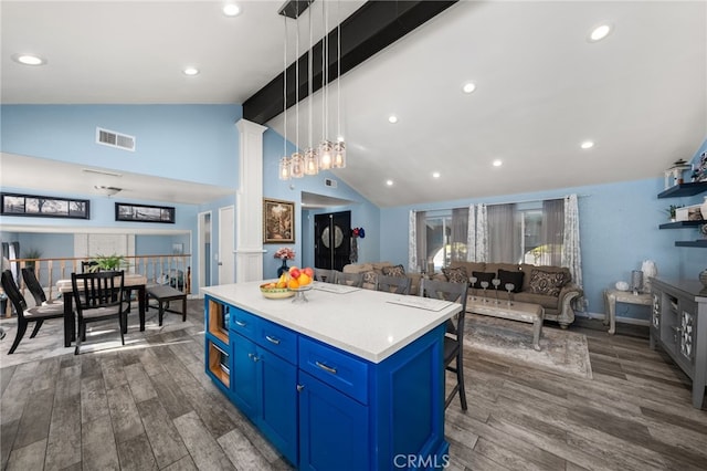 kitchen featuring decorative light fixtures, a kitchen island, a breakfast bar, dark hardwood / wood-style flooring, and blue cabinets