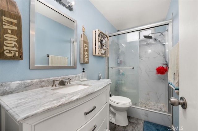 bathroom featuring toilet, hardwood / wood-style floors, vanity, and an enclosed shower