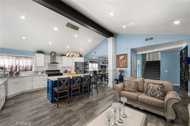 living room with sink, hardwood / wood-style floors, and lofted ceiling with beams