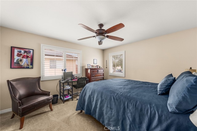 bedroom featuring ceiling fan, light colored carpet, and multiple windows