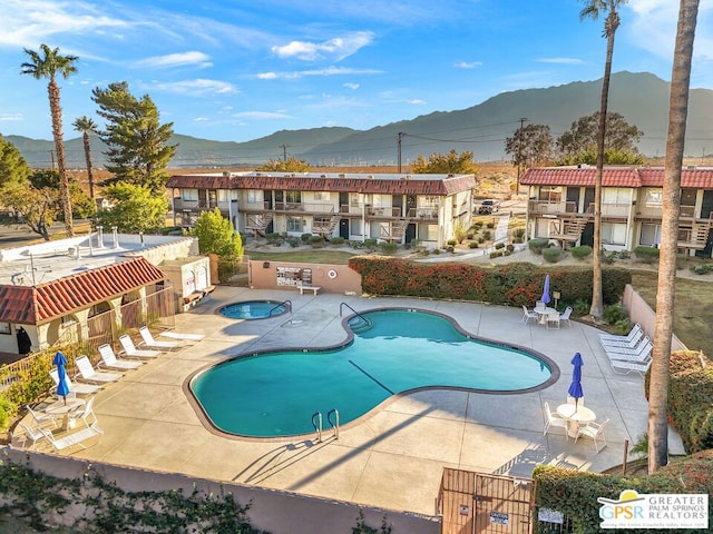 view of swimming pool featuring a patio area and a mountain view