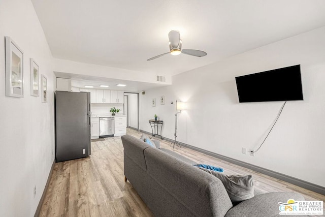 living room with ceiling fan and light hardwood / wood-style flooring