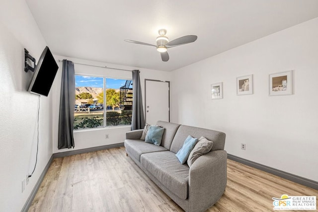 living room featuring ceiling fan and light hardwood / wood-style floors