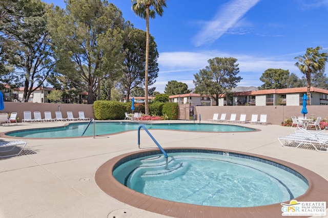 view of swimming pool with a patio area and a community hot tub