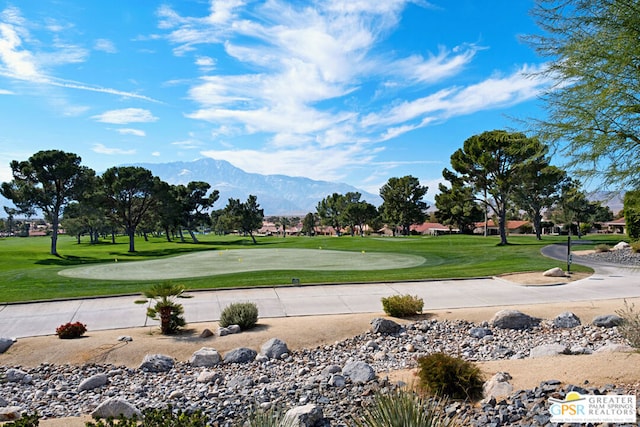 surrounding community with a mountain view and a yard