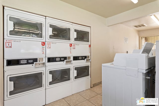 laundry room featuring washer and clothes dryer, stacked washer / drying machine, and light tile patterned flooring