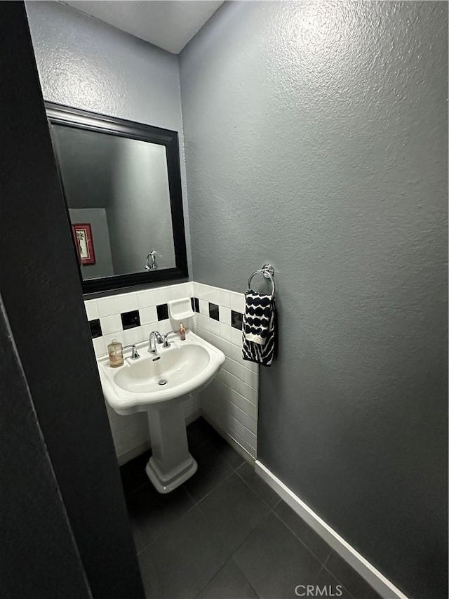 bathroom with tile patterned flooring and a textured wall