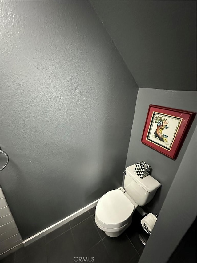 bathroom featuring toilet, tile patterned floors, and lofted ceiling