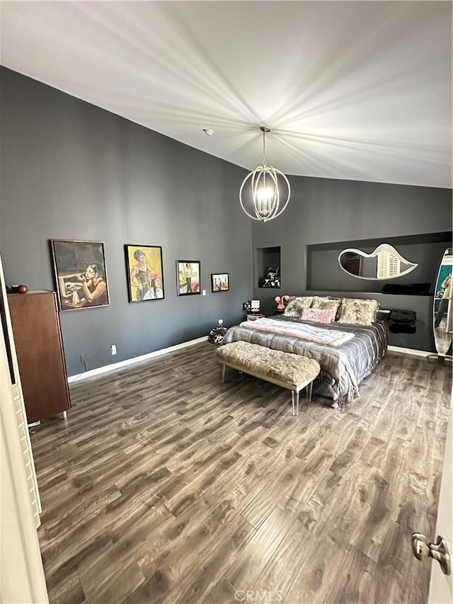 bedroom with a chandelier, hardwood / wood-style flooring, and lofted ceiling