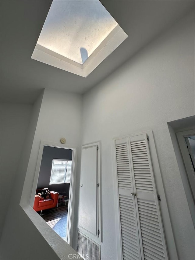 corridor with a raised ceiling and wood-type flooring