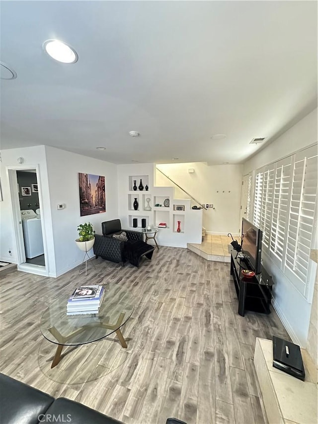 living room with hardwood / wood-style floors and washer / dryer