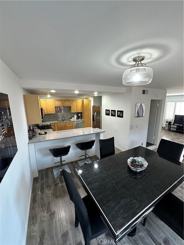 dining space featuring baseboards, dark wood finished floors, visible vents, and recessed lighting