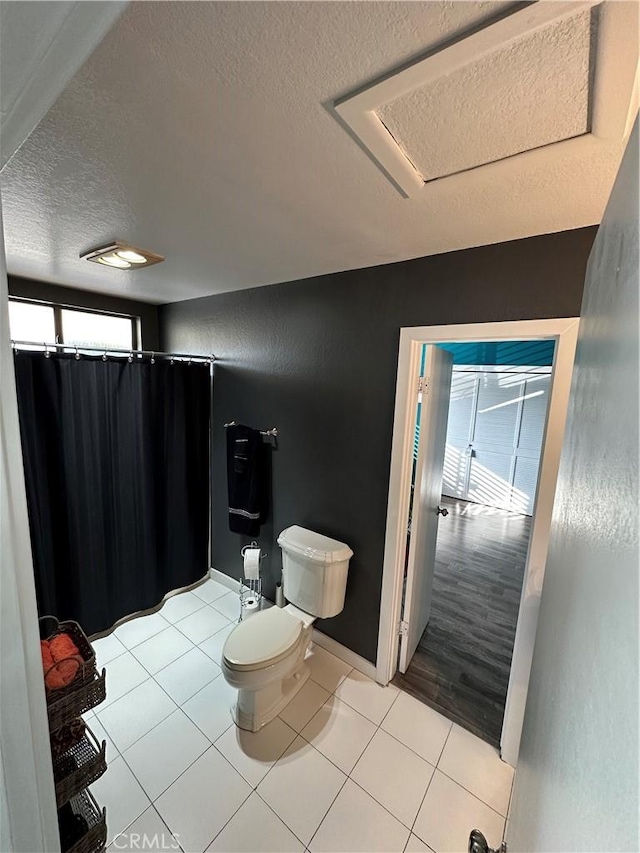 bathroom with a textured ceiling, hardwood / wood-style flooring, and toilet