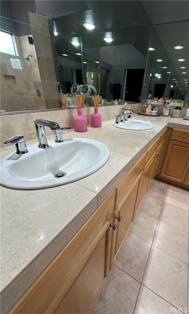 bathroom with tile patterned flooring, vanity, and a shower