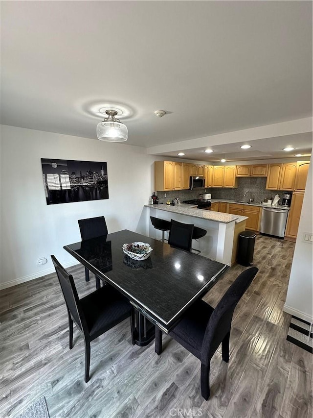 dining area featuring recessed lighting, baseboards, and wood finished floors