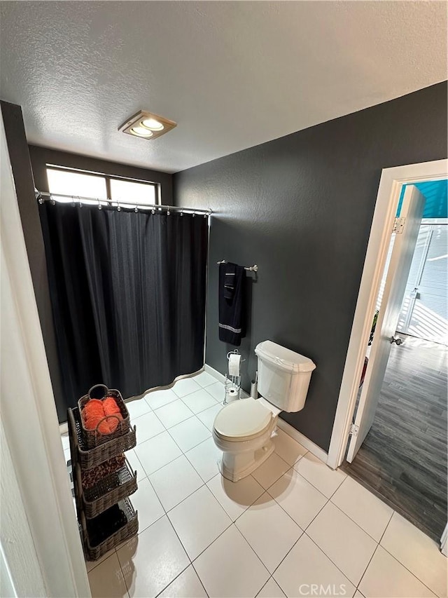 bathroom with toilet, a textured ceiling, and hardwood / wood-style flooring