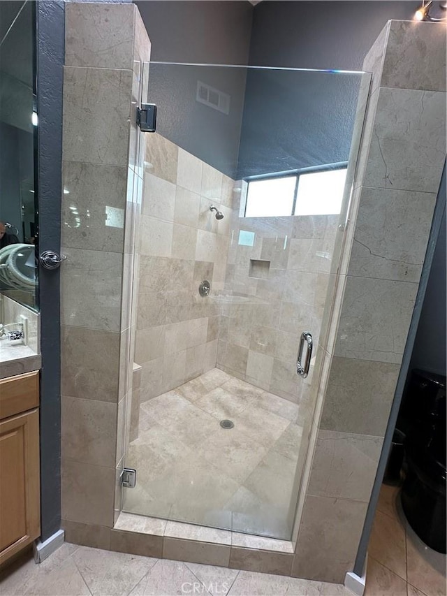 bathroom featuring tile patterned flooring, vanity, and an enclosed shower