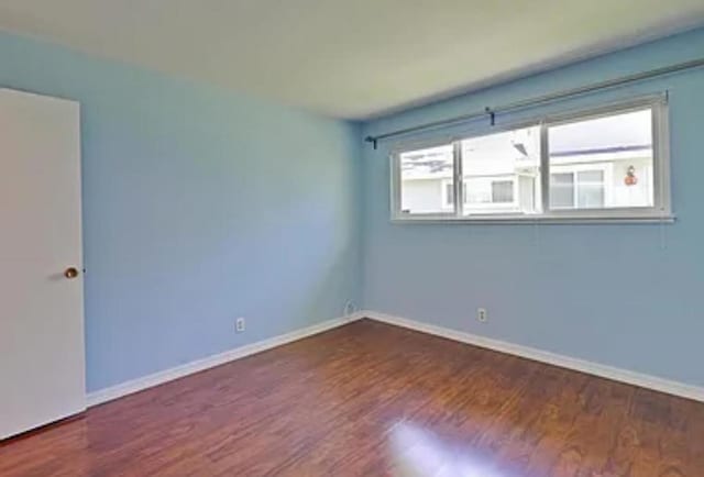 empty room with dark hardwood / wood-style flooring