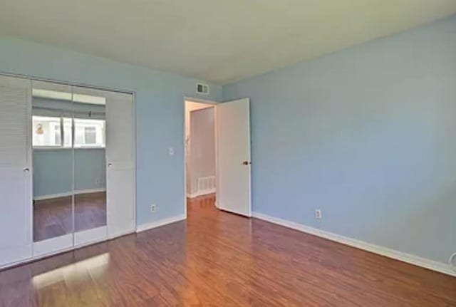 unfurnished bedroom featuring wood-type flooring and a closet