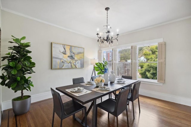 dining space with crown molding, wood-type flooring, and a chandelier