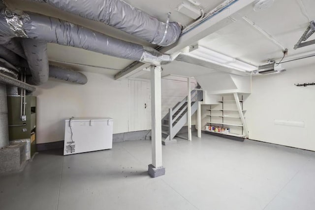 basement featuring fridge and heating unit