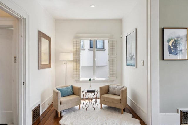 living area featuring crown molding and wood-type flooring