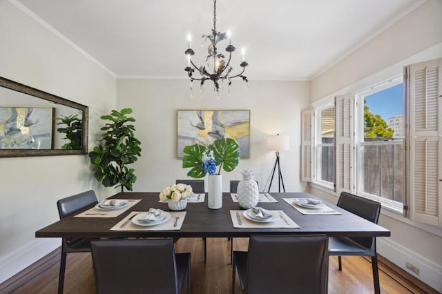 dining room with ornamental molding, wood-type flooring, and a notable chandelier