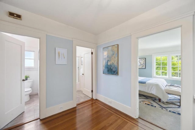 bedroom featuring hardwood / wood-style flooring and ensuite bathroom