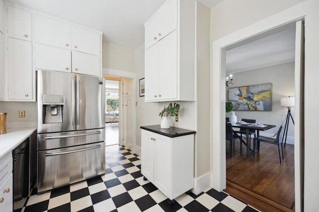 kitchen with white cabinetry, stainless steel fridge, and black dishwasher