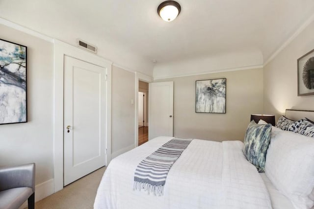 bedroom with crown molding and light colored carpet