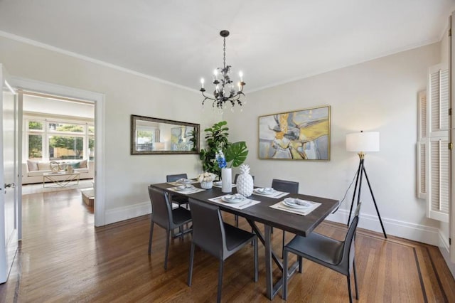 dining room featuring dark wood-type flooring, crown molding, and a notable chandelier