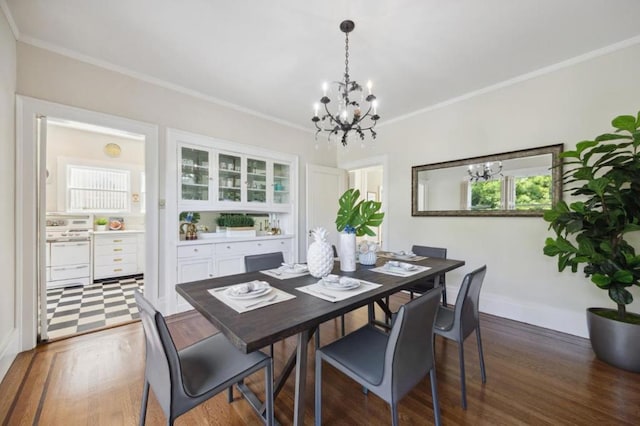 dining area featuring dark wood-type flooring, crown molding, and a chandelier