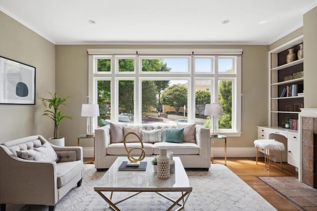 interior space with a tiled fireplace, light hardwood / wood-style flooring, and ornamental molding