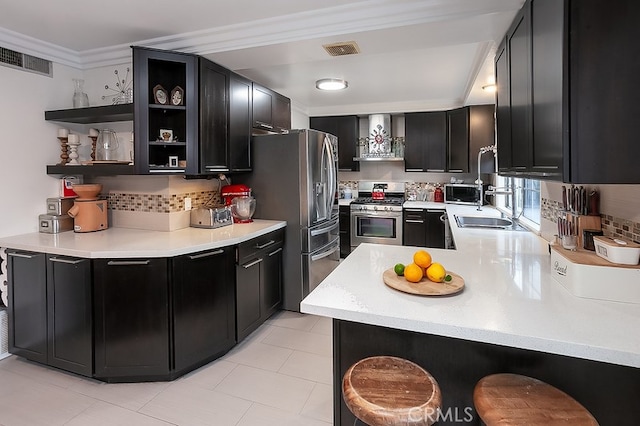 kitchen with wall chimney exhaust hood, kitchen peninsula, ornamental molding, and appliances with stainless steel finishes