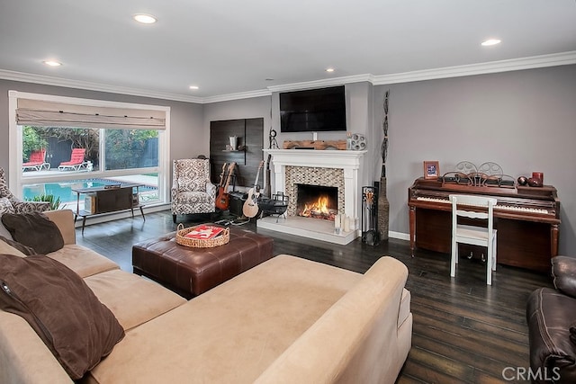 living room with a tile fireplace, crown molding, and dark wood-type flooring