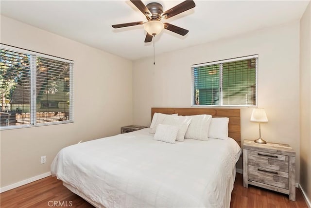 bedroom with dark hardwood / wood-style floors and ceiling fan