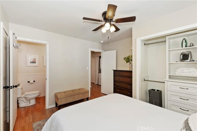 bedroom featuring light wood-type flooring, ceiling fan, and connected bathroom