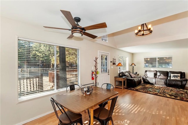 dining space featuring ceiling fan with notable chandelier and light hardwood / wood-style flooring