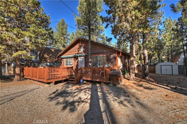 view of front of home with a storage shed and a deck