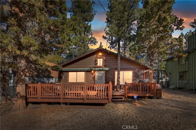 back house at dusk with a deck