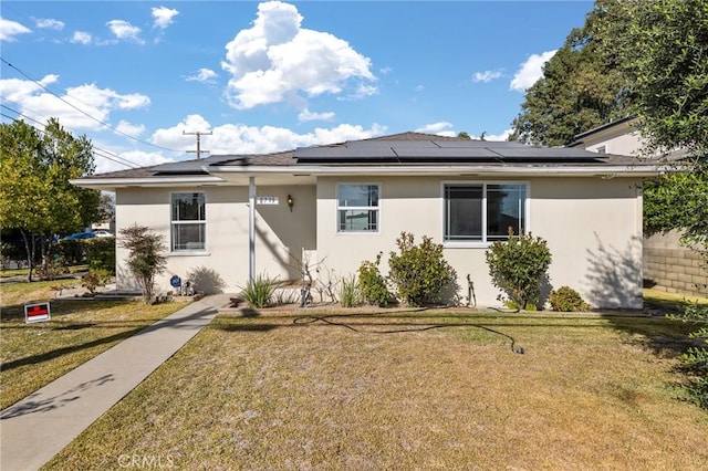 rear view of property with solar panels and a lawn