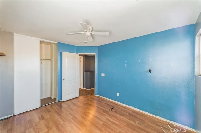 unfurnished bedroom featuring ceiling fan, light wood-type flooring, and a closet