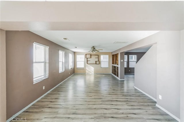 unfurnished living room featuring light wood-type flooring and ceiling fan