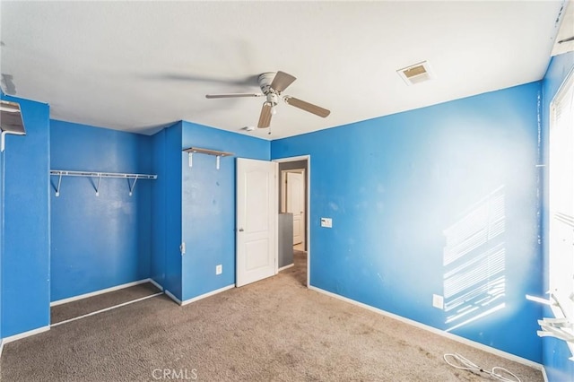 unfurnished bedroom featuring ceiling fan, a closet, and carpet