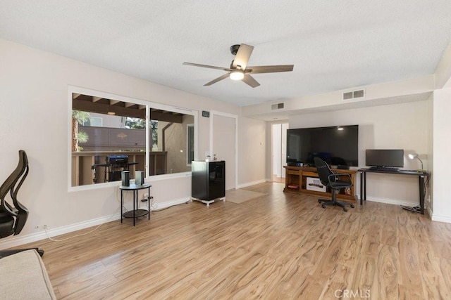 home office featuring a textured ceiling, light hardwood / wood-style floors, and ceiling fan