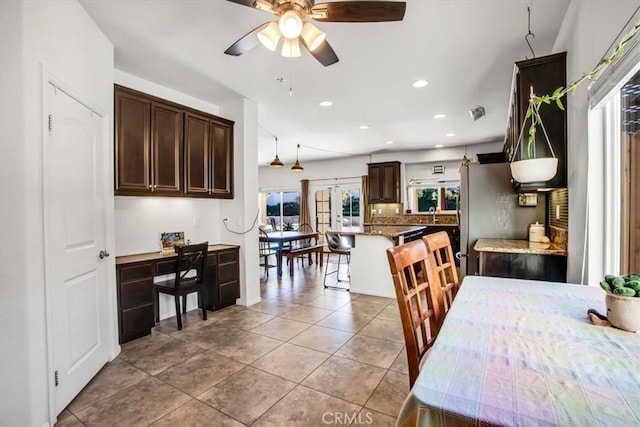 tiled dining space featuring ceiling fan, sink, and french doors