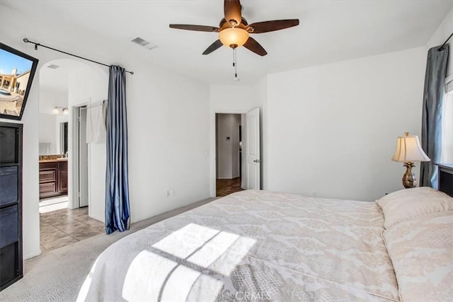 carpeted bedroom with connected bathroom and ceiling fan