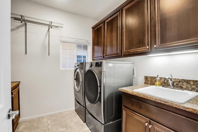 washroom with cabinets, light tile patterned floors, sink, and washing machine and clothes dryer