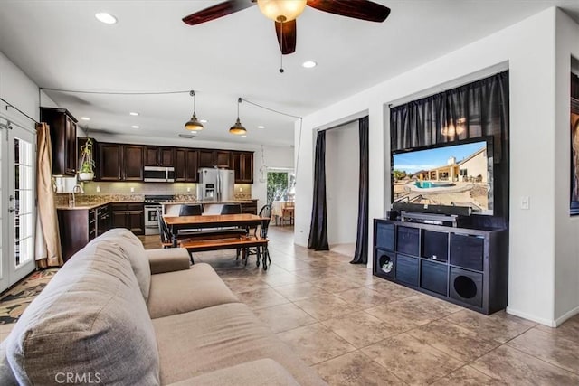 tiled living room with ceiling fan, sink, and french doors